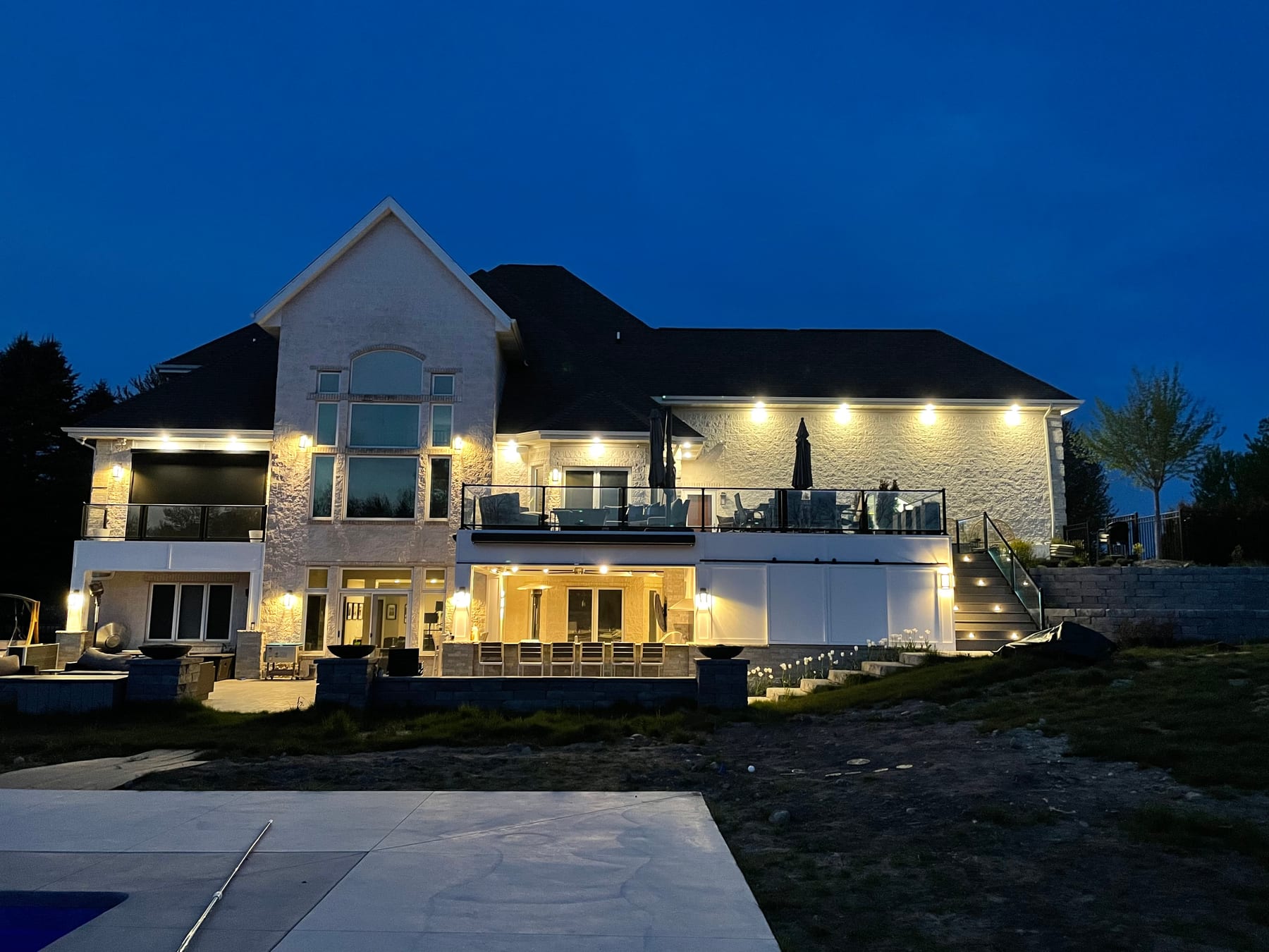 A West Michigan home at dusk with exterior and landscape lighting by Fine Line Electric