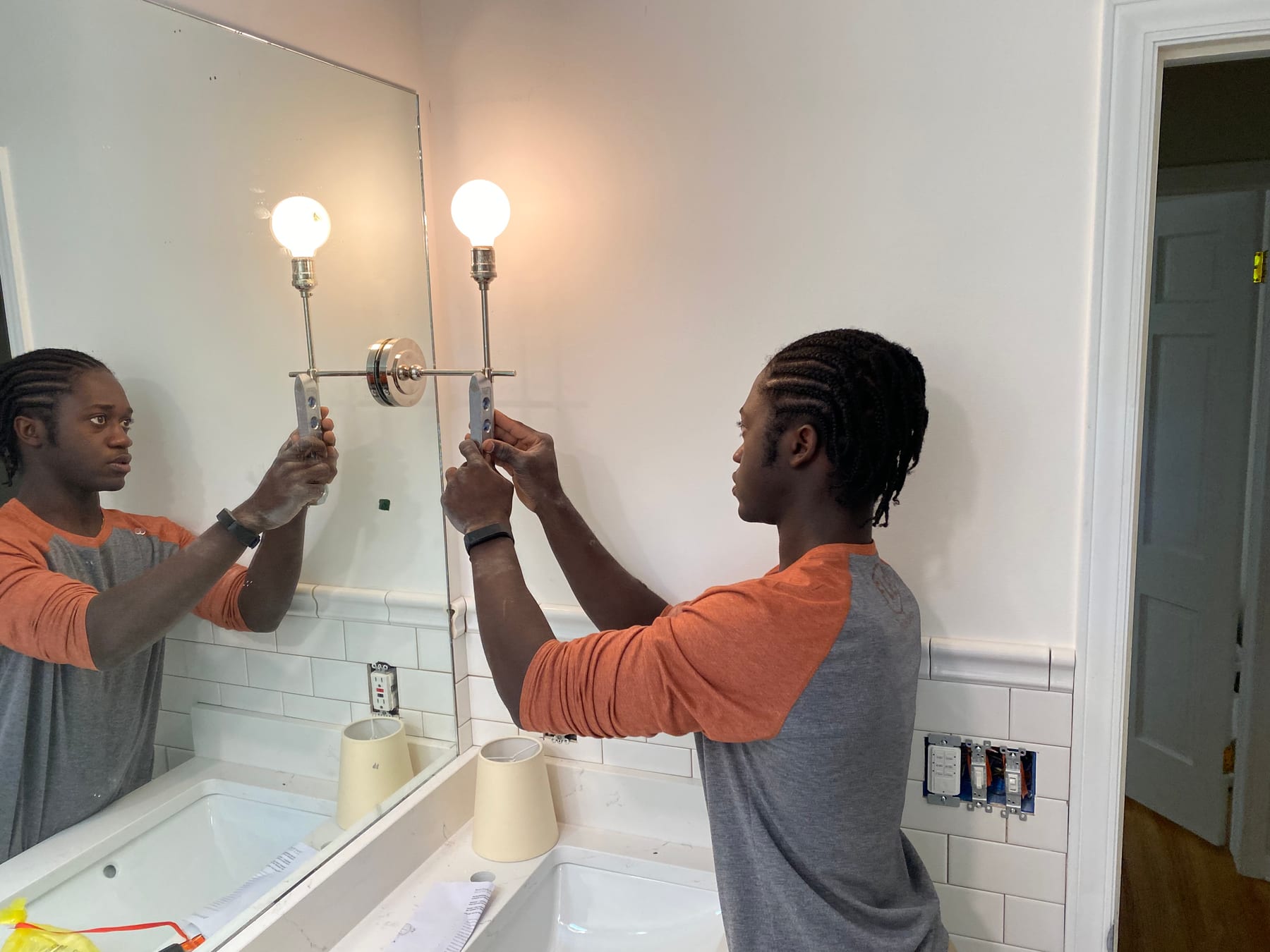 Two Fine Line electricians installing a vanity light
